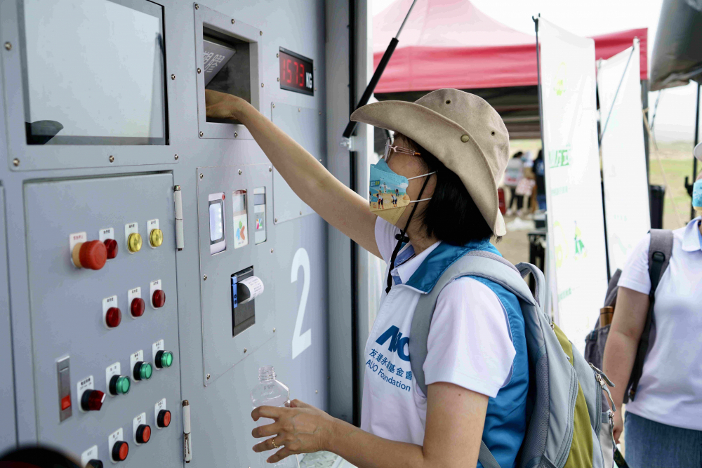 志工們將拾起的寶特瓶投入「好歸塑專車」，讓廢棄塑料空瓶可以直接粉碎、縮小體積，未來將可再製成購物袋、寶特衣、悠遊卡等生活用品